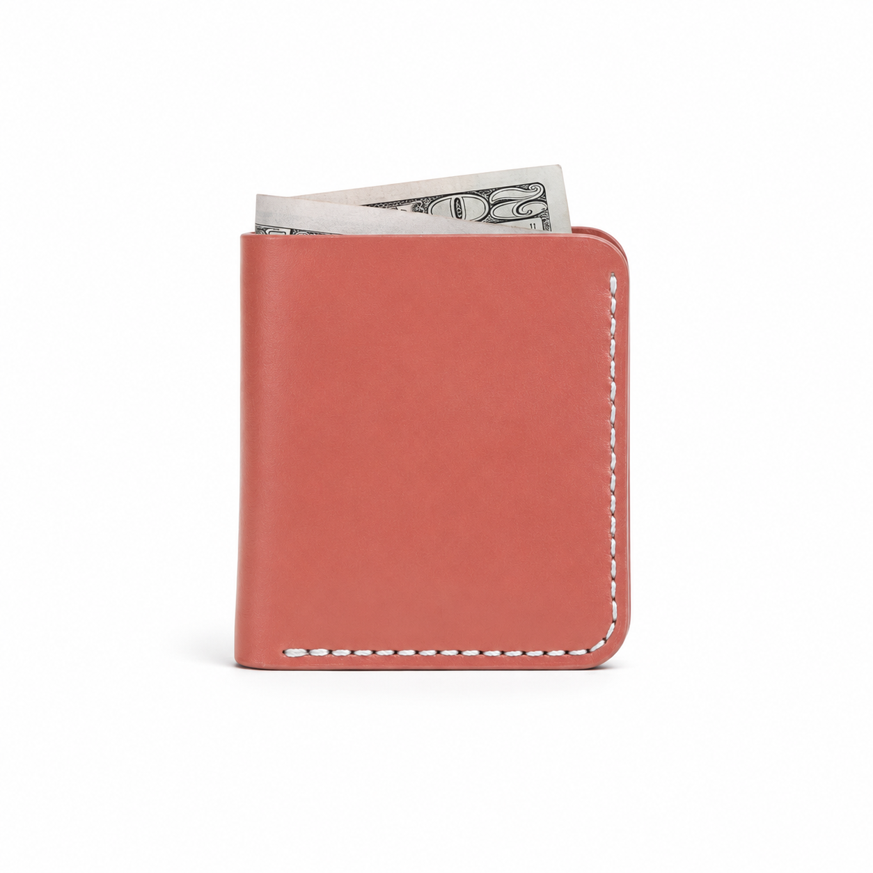 A coral pink leather bi-fold wallet with white contrast stitching, shown with a dollar bill partially inserted, on a clean white background.